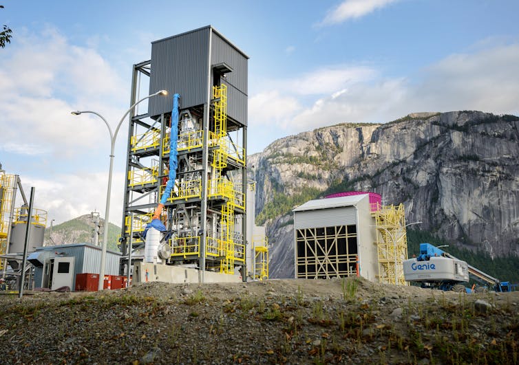 A tall metal structure with a mountain in the background.