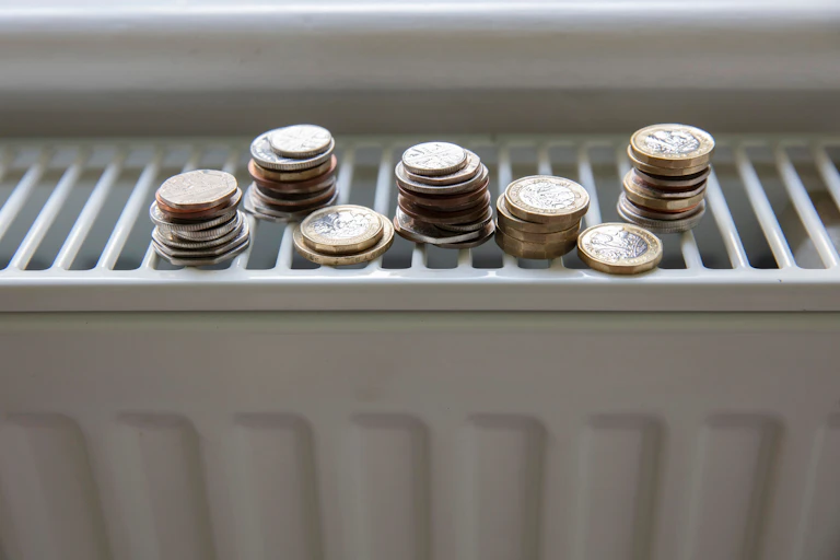 Small piles of coins on a radiator.