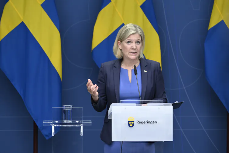 Magdalena Andersson at a podium in front of a Swedish flag.