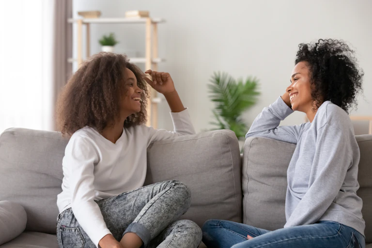 femme rit avec sa fille sur le sofa