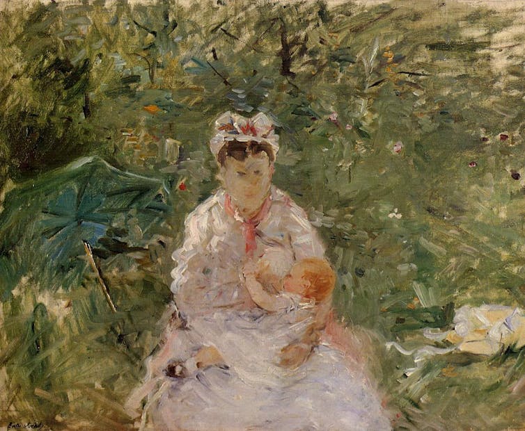 A woman breastfeeds a child.