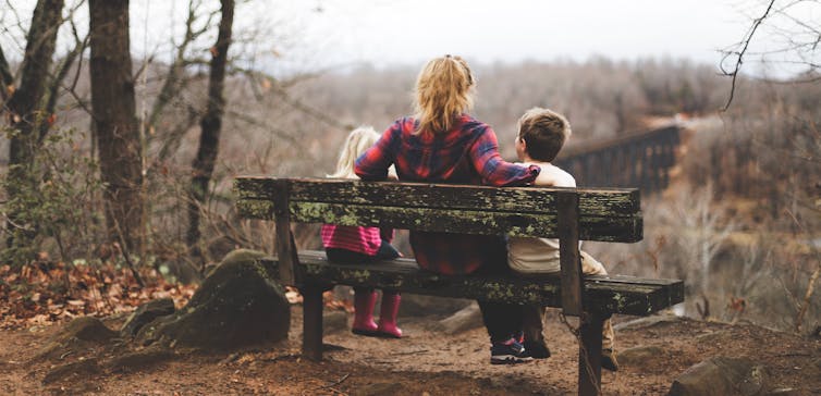 A parent talks to her children in the park.