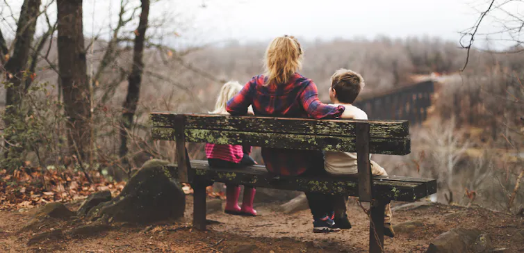 A parent talks to her children in the park.