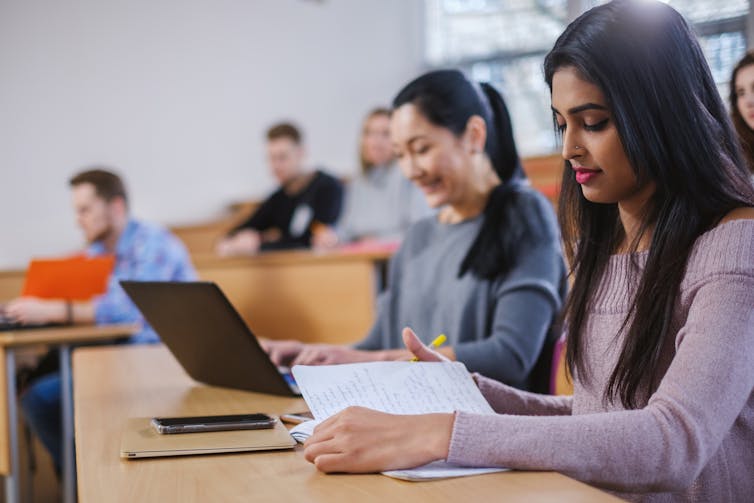 University students sit with laptops.