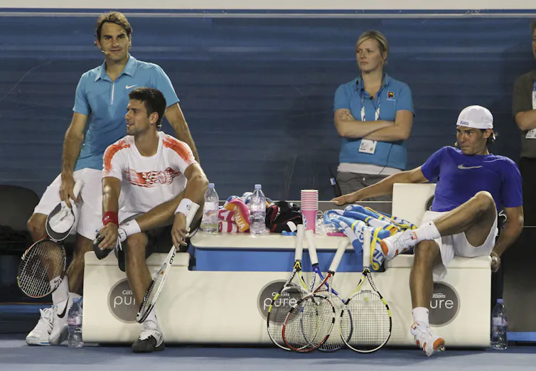 The three men watching a game.