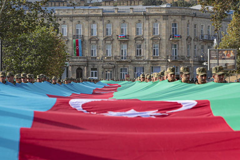 zeri soldiers carry a large-scale national flag on the anniversary of the end of the 2020 war over the Nagorno-Karabakh region between Azerbaijan and Armenia, in downtown Baku, November 2021.