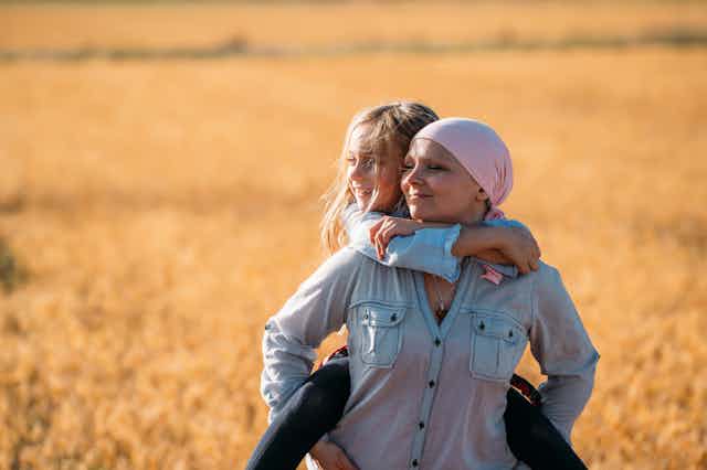 Woman with scarf on her head carrying her daughter