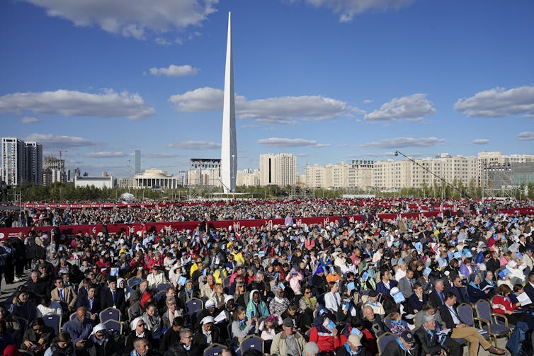 Hundreds of people seated in rows in an open ground in Nur-Sultan, the capital city of Kazakhstan