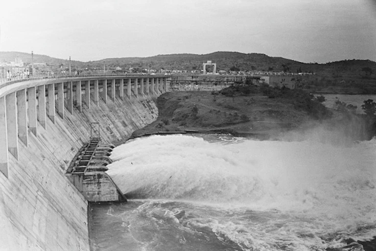 Water gushing out of sluice gates on the wall of a dam.