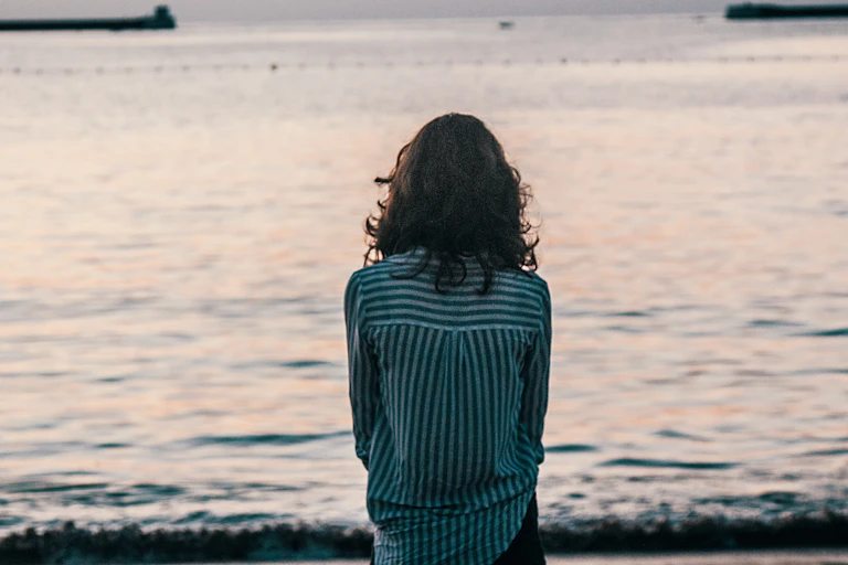 Woman stares out to sea