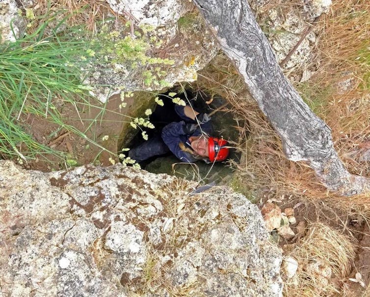 woman smiles as she descends into cave