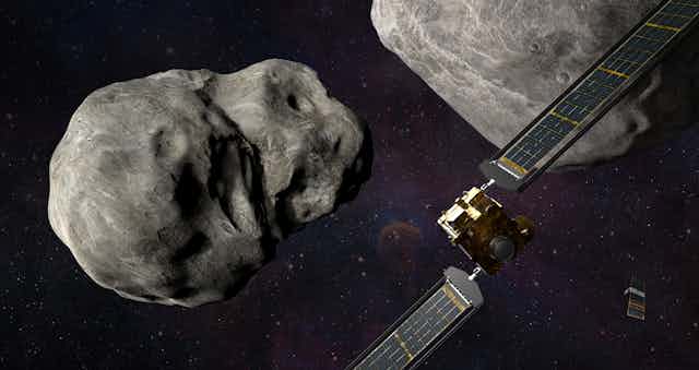 A large spacecraft and a smaller satellite approaching an asteroid in space.