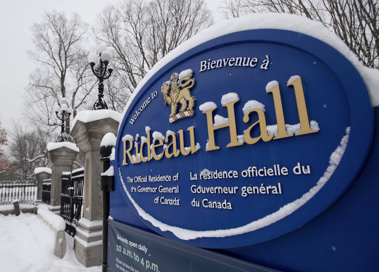 A blue snow-covered sign that says Rideau Hall in gold lettering