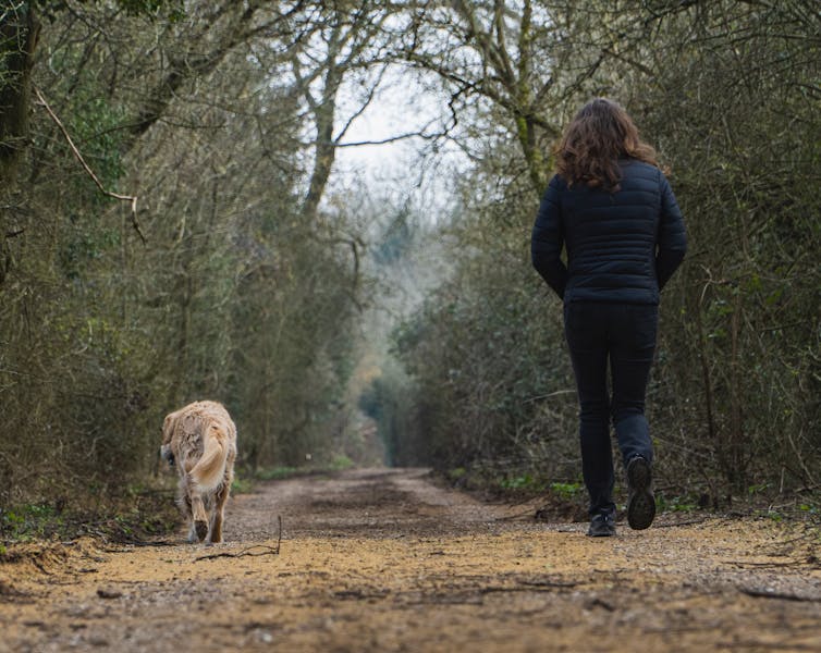Woman walks in the country with her dog