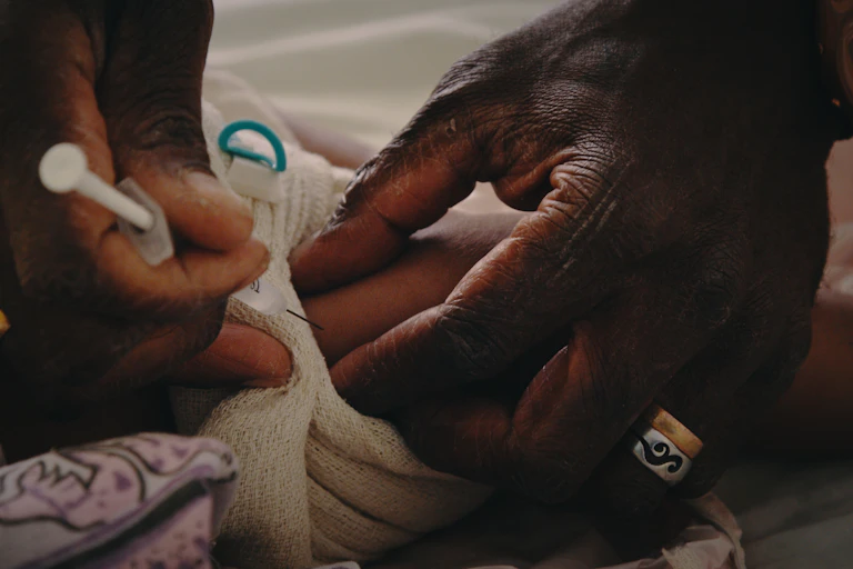 Closed up of hands administering vaccine on a baby