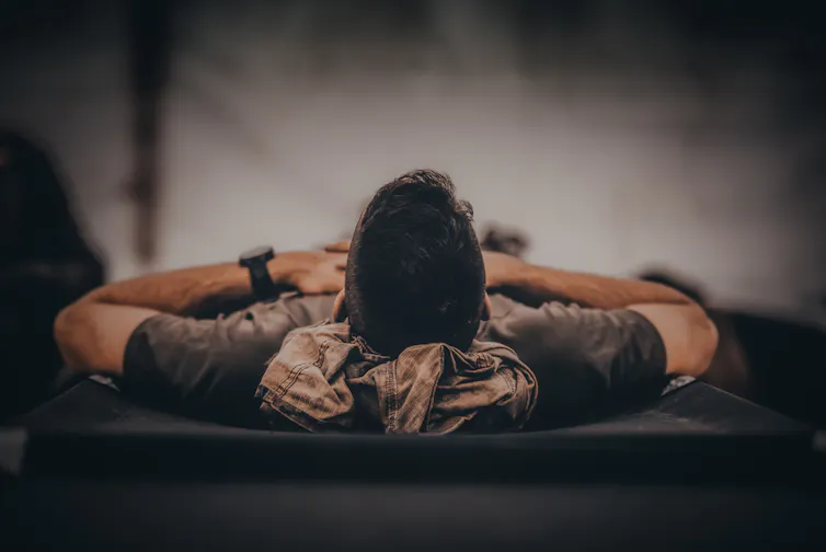 Man in army uniform lying on bed.