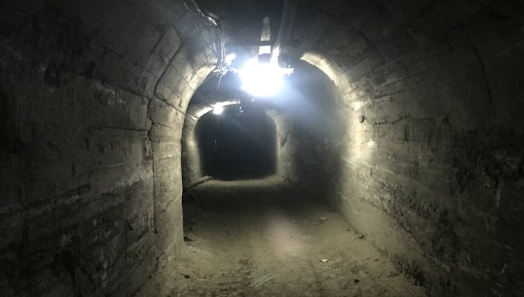 A mine corridor lit with electric lights