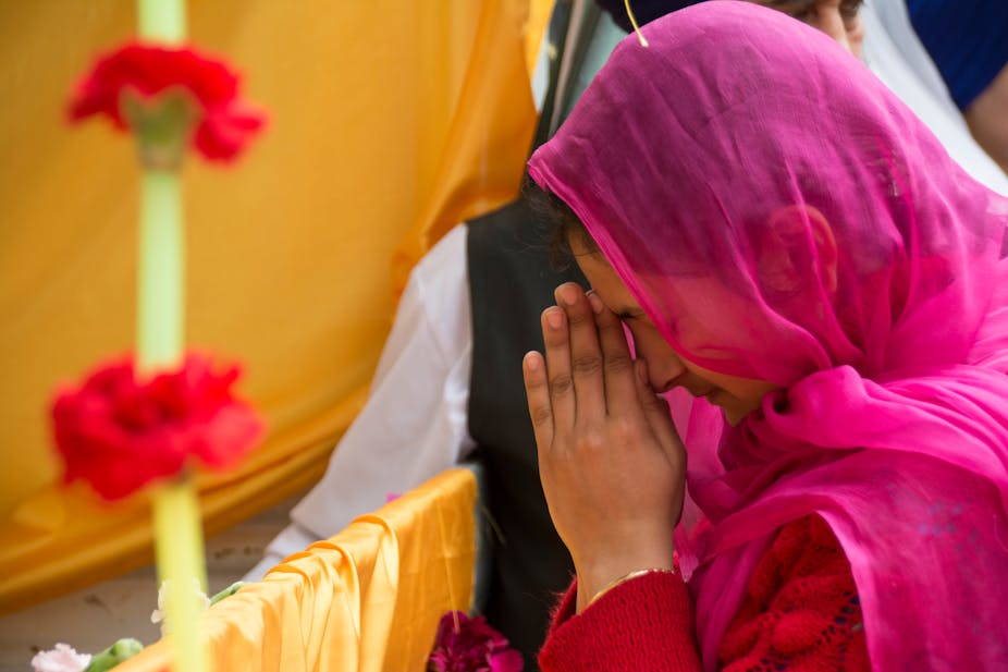 Woman wearing head covering prays