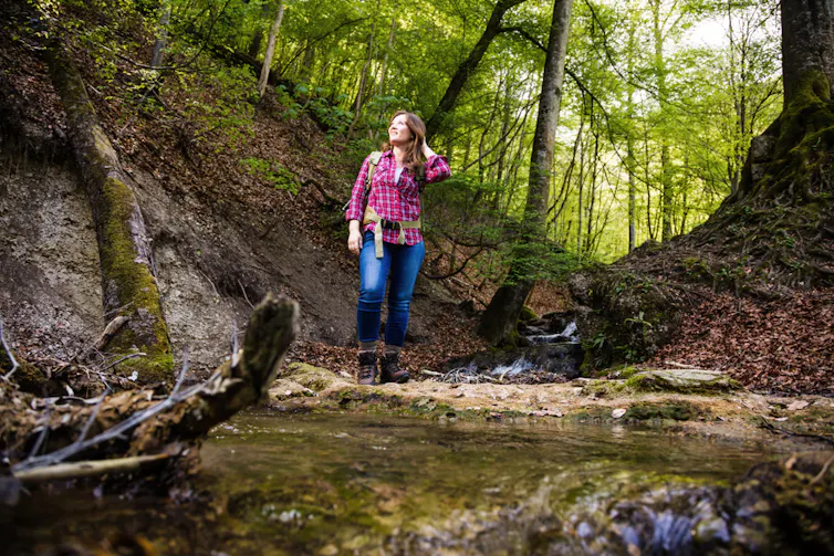Une jeune femme fait un trek en forêt