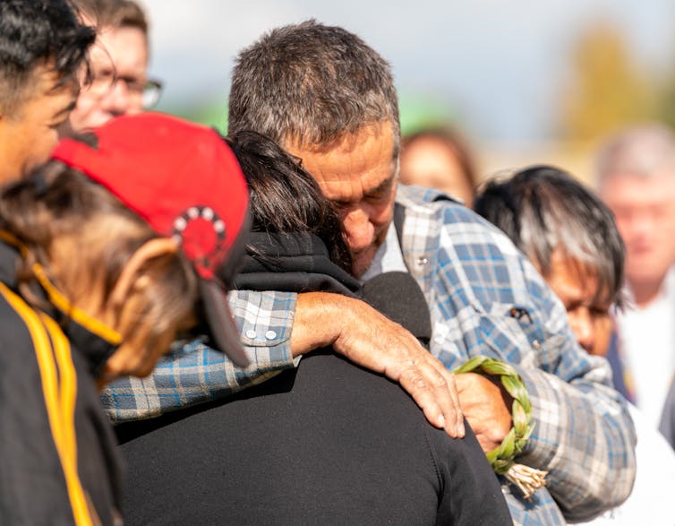 A man hugs a woman.