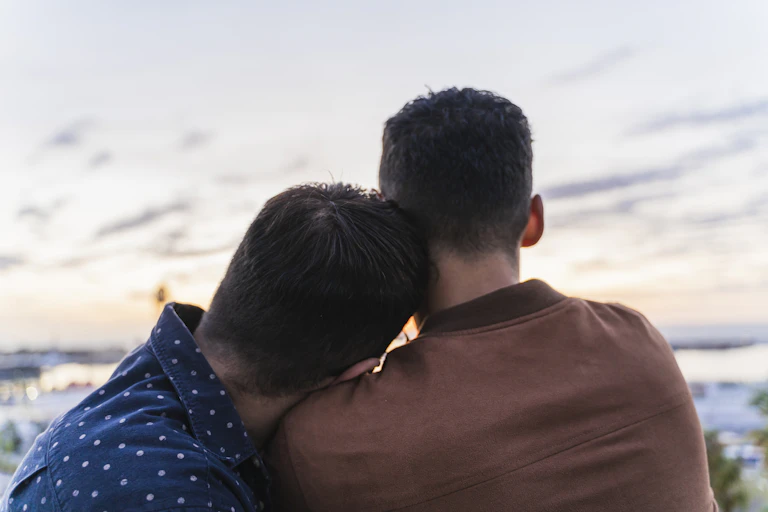 Close-up rear view of two people looking at a scenic view