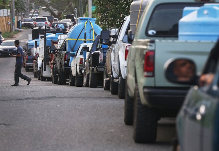 A long line of cars idles on a city street