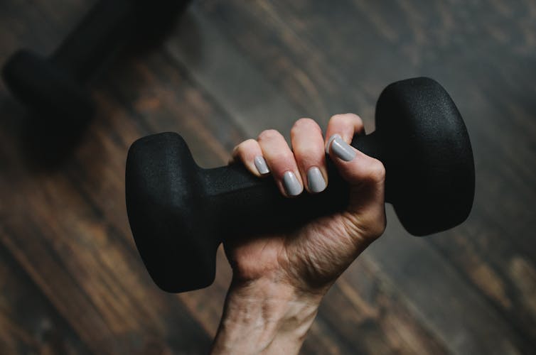 A person holds a small handweight.