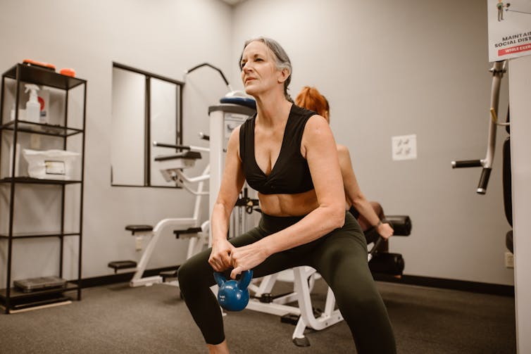 A woman works out using a smaller weight.