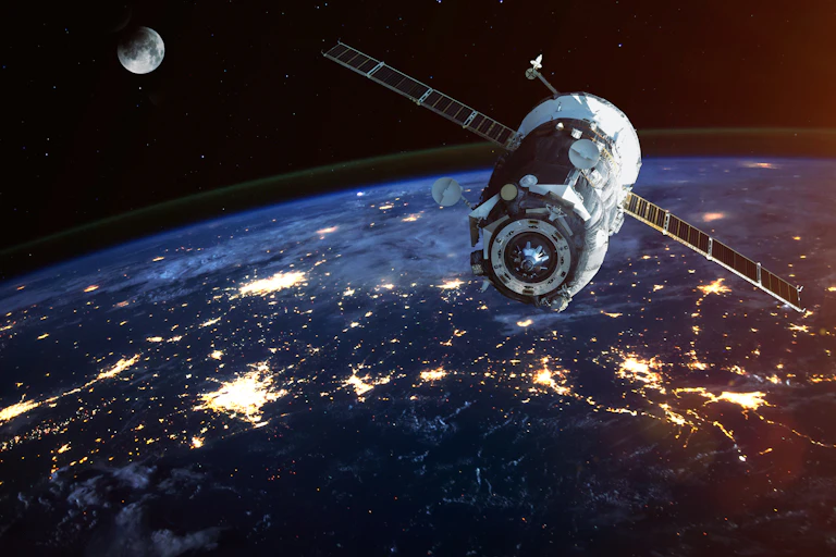 Un satellite au-dessus de la Terre avec la Lune au fond