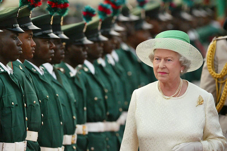 a line up of soldiers in green next to the queen in white with a green hat