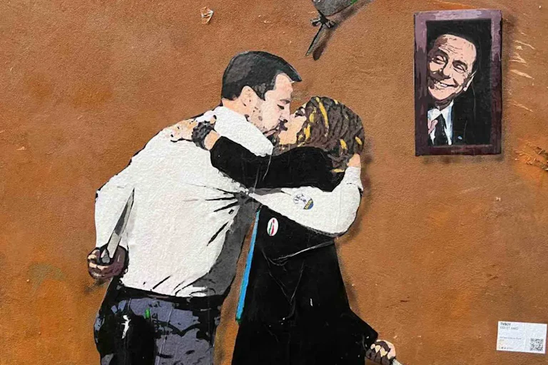 Peinture murale représentant un baiser entre Matteo Salvini et Giorgia Meloni sous l'oeil de Silvio Berlusconi