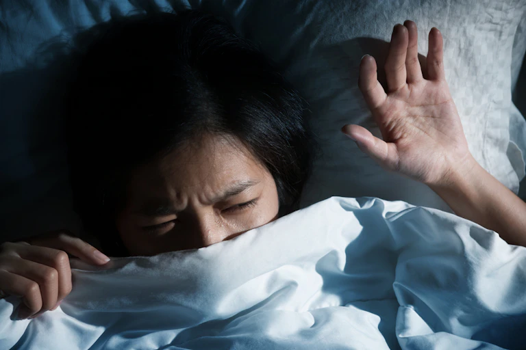 femme apeurée dans un lit