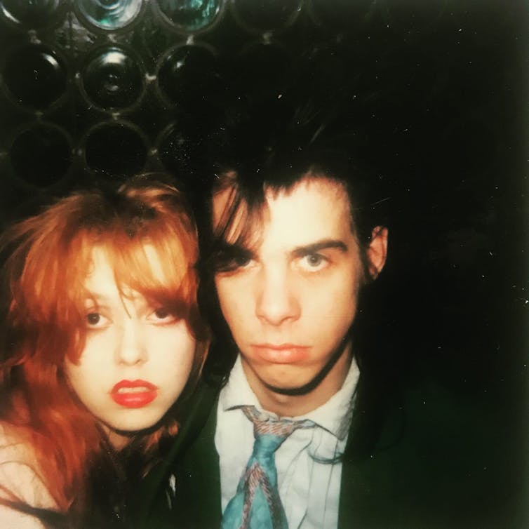 A red-haired young woman and dark-haired man in suit and tie. Anita Lane and Nick Cave