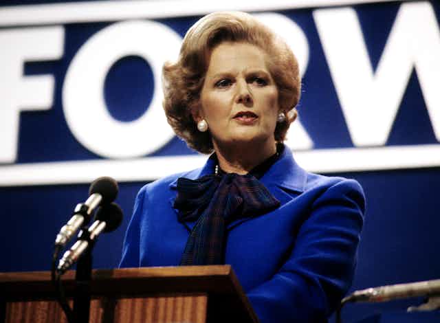 Margaret Thatcher at a podium.