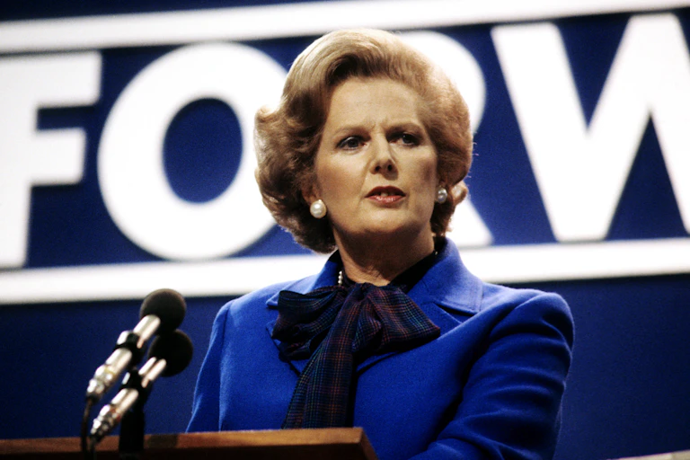 Margaret Thatcher at a podium.