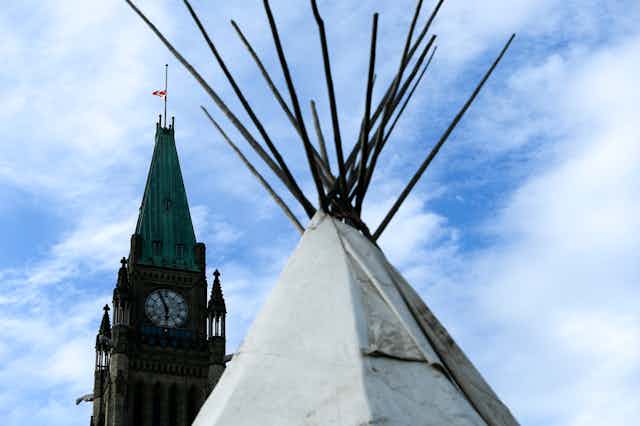 The top of a teepee with parliament's Peace Tower in the background.