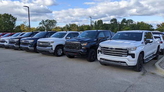 Large pickup trucks parked in a long row