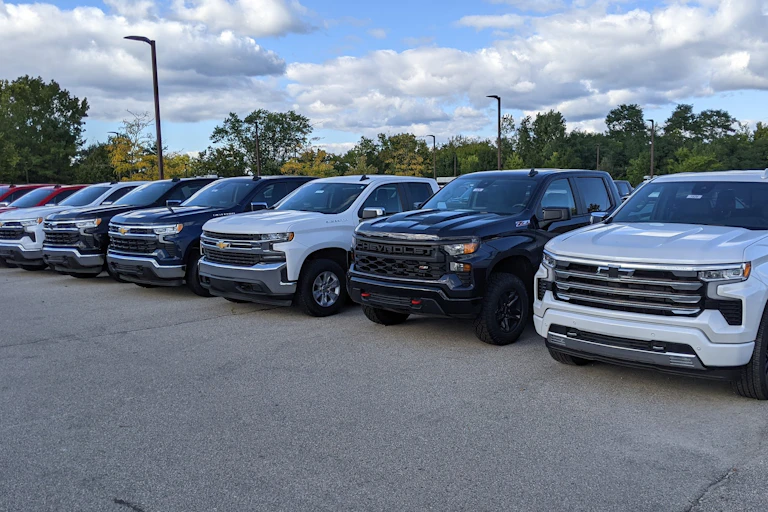Large pickup trucks parked in a long row
