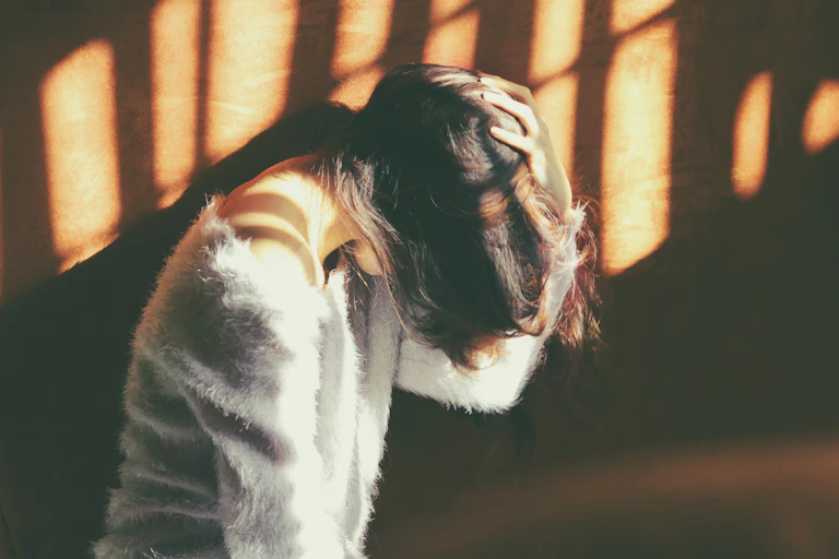 girl with head down and long hair over face