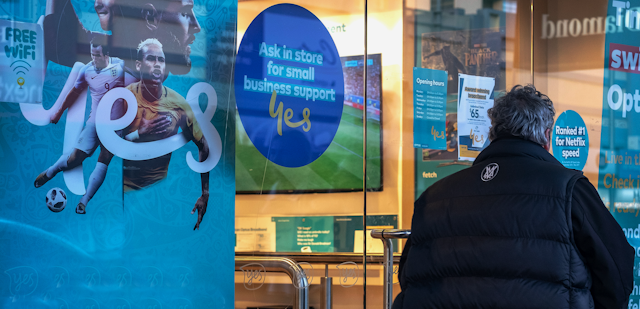 Person standing outside Optus shop window
