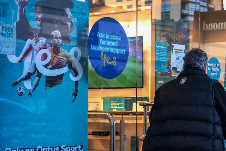 Person standing outside Optus shop window