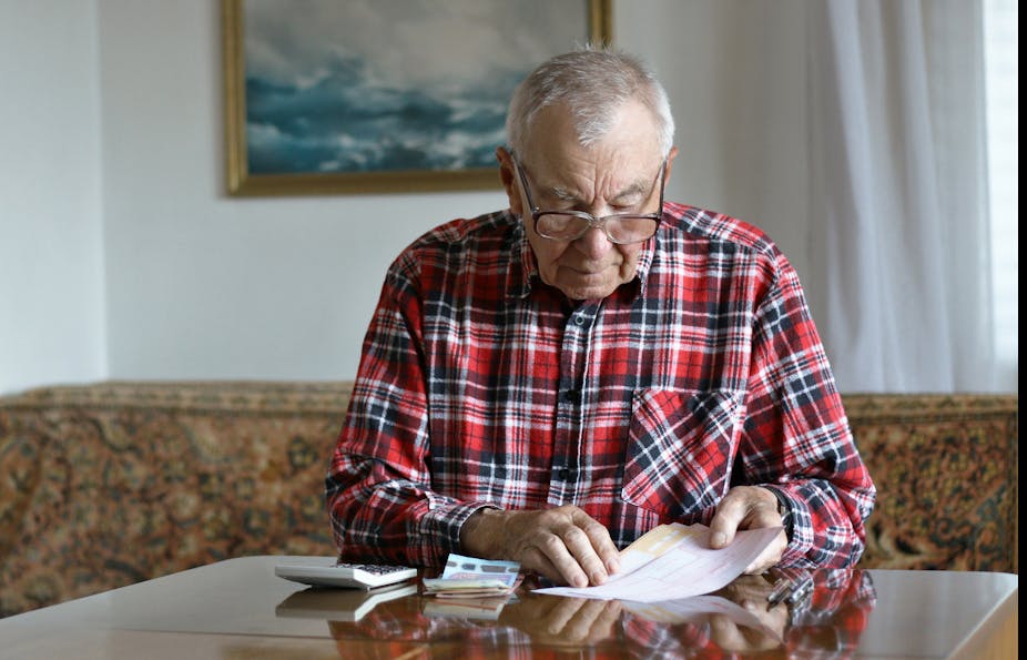 A senior man calculating bills.