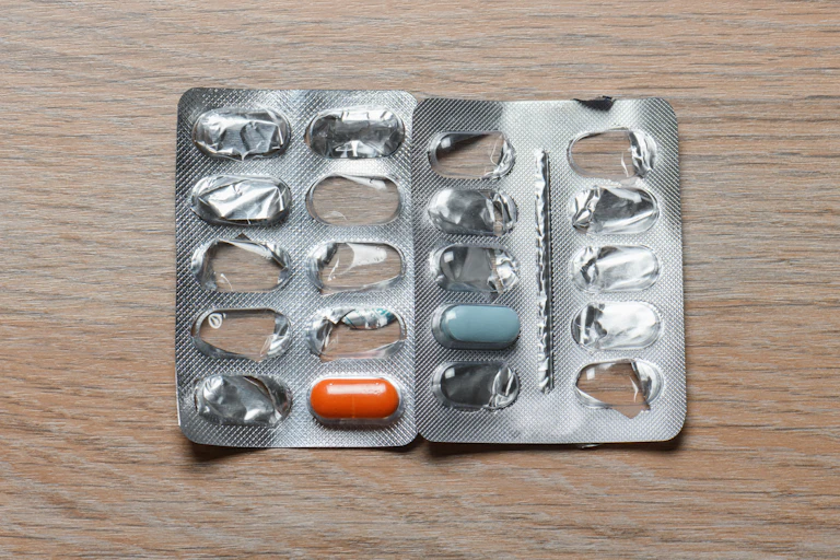 Two blister packs of medication, both of which only have one pill left.
