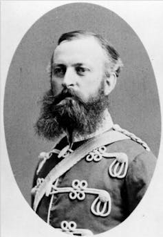 Black and white photo of a man seen in a military uniform.