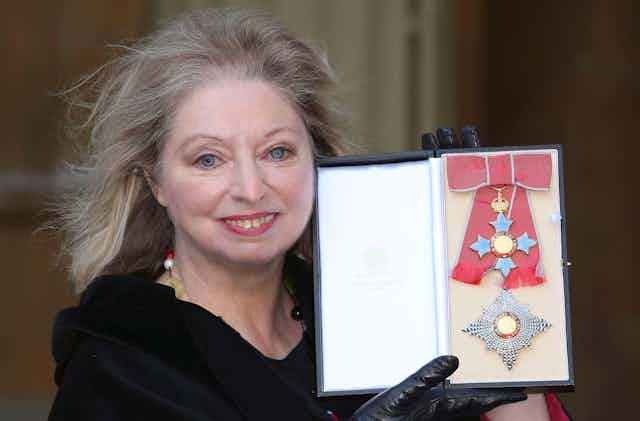 Dame Hilary Mantel dressed in black with her honour at Buckingham Palace.