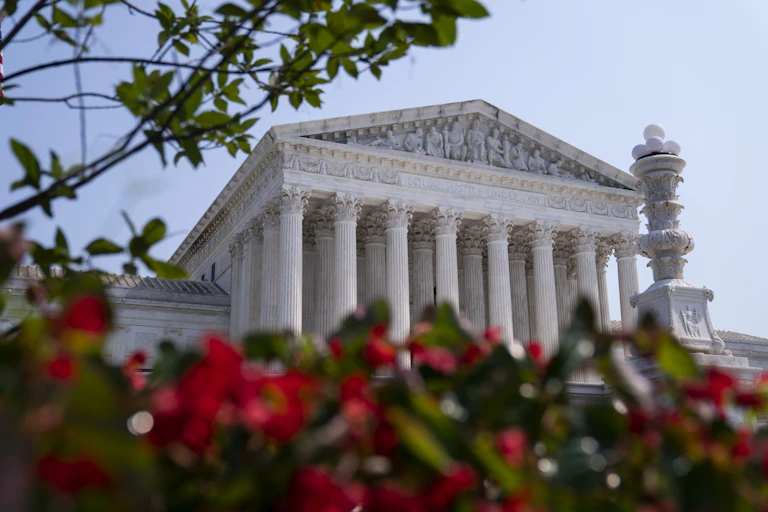 The exterior of the Supreme Court is shown, with red flowers in front