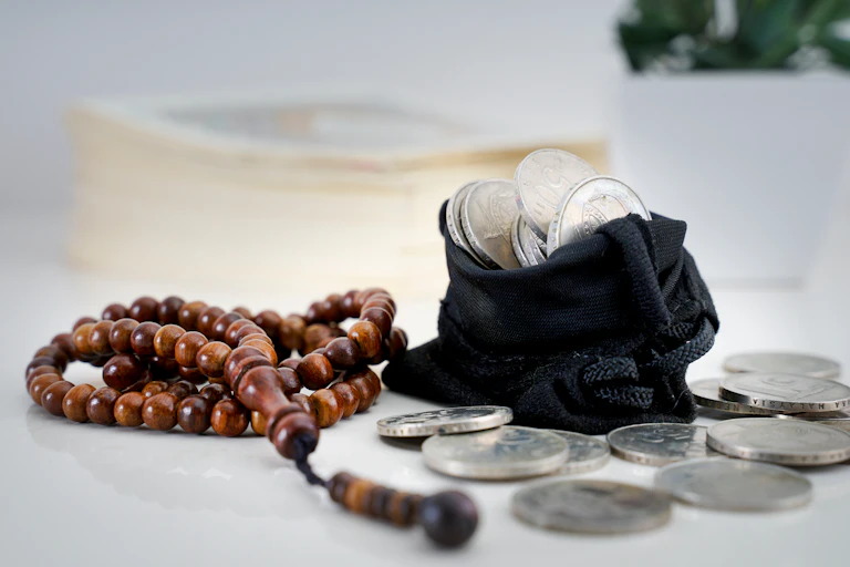 a photograph of a rosary and a bag of silver coins