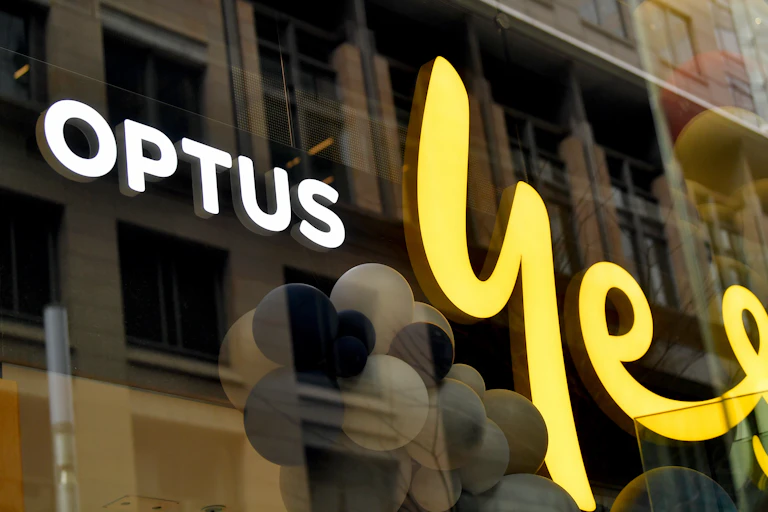 Signage of a glass-fronted shop that says OPTUS Yes