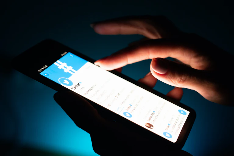 Manos sujetan un móvil con la pantalla iluminada.