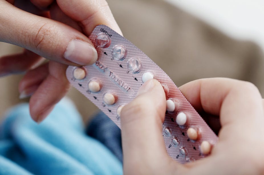 A women holds a blister pack of birth control pills.